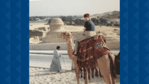 Young Janet sitting on a camel in the desert.