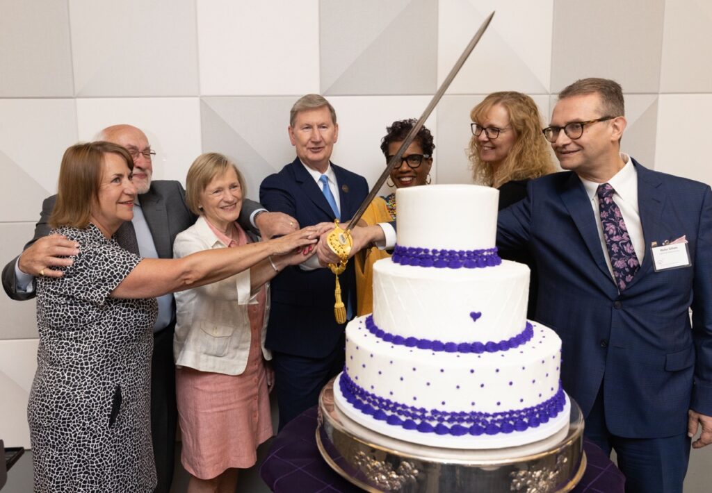President Carter and BECI staff cut into giant cake with a sword to celebrate the pledge.