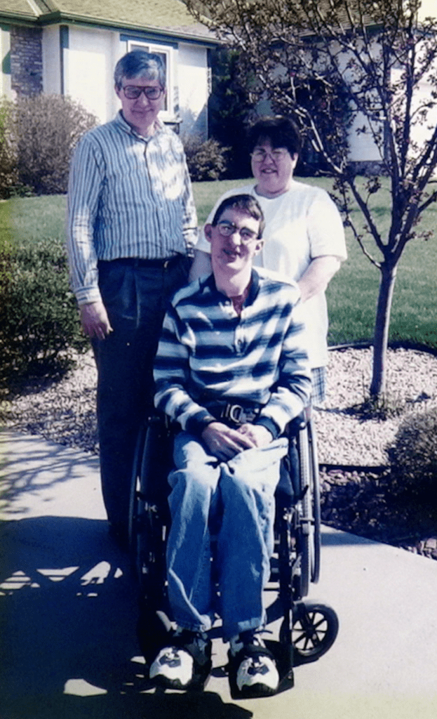 Bob Barb and Andrew Blair pose with their son who sits in a wheelchair.