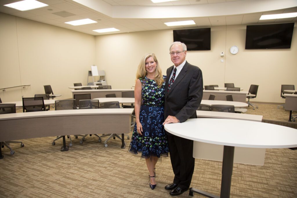 Couple poses in empty classroom at UNL College of Business.