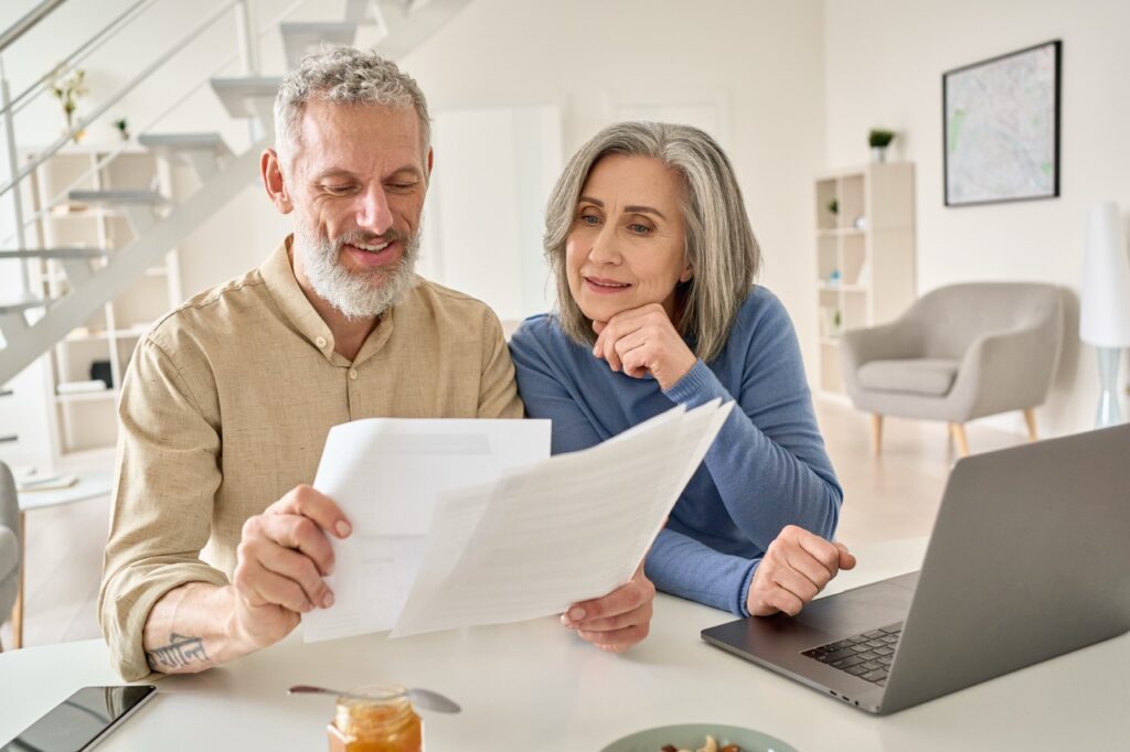A senior couple happily looking over a document at the kitchen island